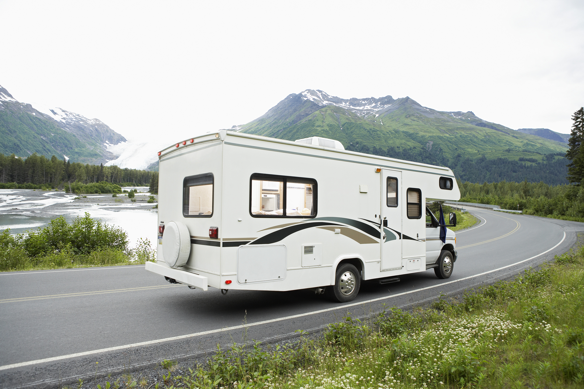 USA, Alaska, recreational vehicle driving on road, side view